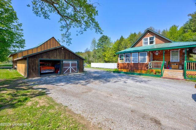 116 Medbury Rd, Greenfield, NY 12859 - view of front of house with a porch, an outdoor structure, a detached garage, and gravel driveway