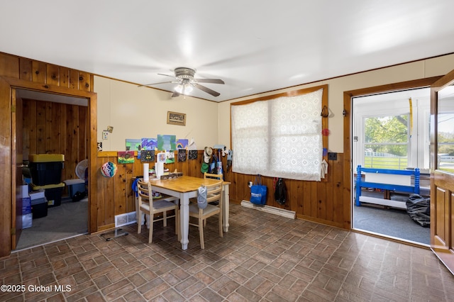 116 Medbury Rd, Greenfield, NY 12859 - dining space featuring wood walls, brick patterned flooring, a ceiling fan, a wainscoted wall, and baseboards