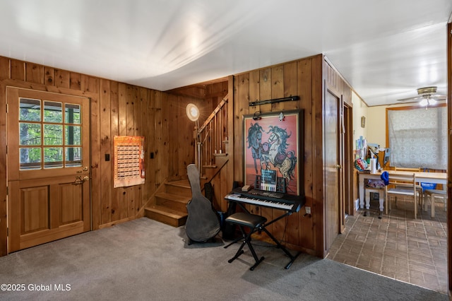 116 Medbury Rd, Greenfield, NY 12859 - carpeted entrance foyer featuring wooden walls, stairway, and a ceiling fan