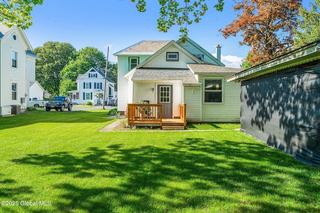 22 Center St, Fort Edward, NY 12828 - rear view of house featuring central air condition unit, a lawn, a deck, and roof with shingles