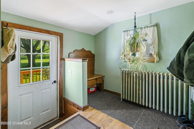 22 Center St, Fort Edward, NY 12828 - doorway featuring radiator, wood finished floors, vaulted ceiling, and baseboards