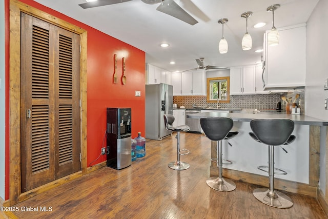 22 Center St, Fort Edward, NY 12828 - kitchen featuring stainless steel appliances, wood finished floors, white cabinets, tasteful backsplash, and a peninsula