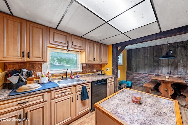 kitchen featuring black dishwasher, a sink, light wood-style flooring, and light countertops
