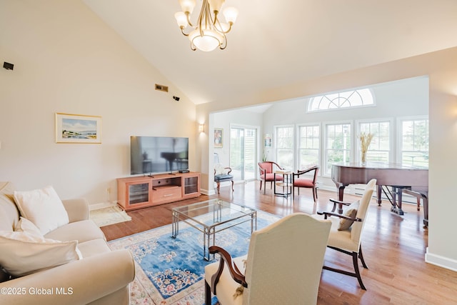 36 Greystone Dr, Guilderland, NY 12186 - living area with light wood finished floors, baseboards, a chandelier, and high vaulted ceiling