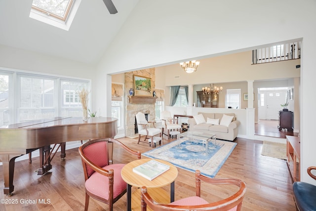 36 Greystone Dr, Guilderland, NY 12186 - living area with high vaulted ceiling, wood finished floors, a chandelier, a fireplace, and baseboards