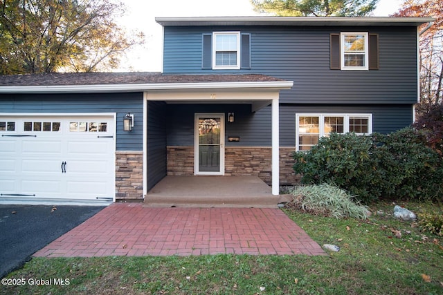 18 Alva St, East Greenbush, NY 12061 - view of front of home with a garage, stone siding, and driveway