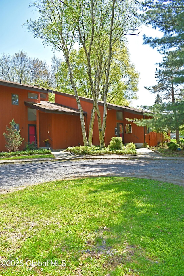 mid-century home featuring a front lawn