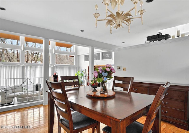 dining room with light wood-type flooring and a chandelier