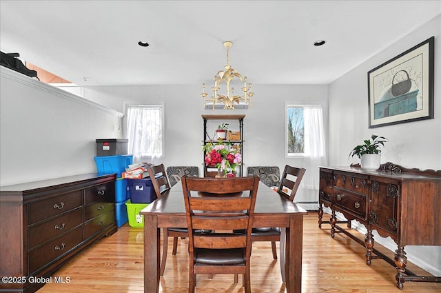 dining room with light wood-type flooring, a chandelier, a baseboard radiator, and recessed lighting