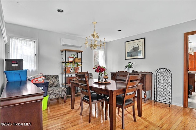 dining space with a chandelier, a wall mounted AC, light wood-style flooring, healthy amount of natural light, and recessed lighting