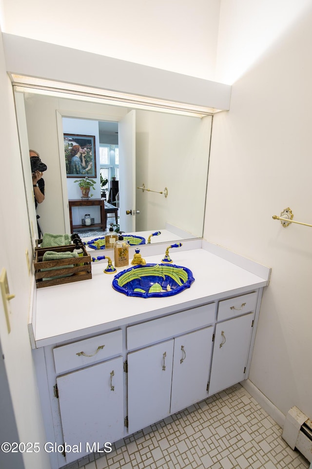 bathroom featuring a baseboard heating unit and vanity