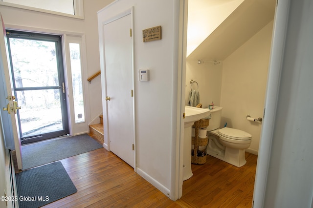 foyer entrance featuring hardwood / wood-style flooring, stairs, and baseboards