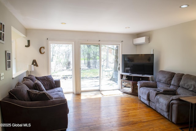 living room featuring a wall mounted AC, hardwood / wood-style floors, and recessed lighting