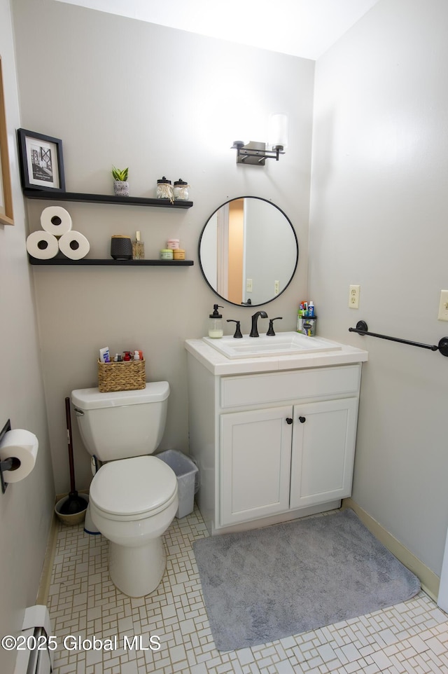 half bath with toilet, vanity, and baseboards