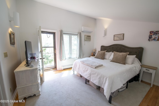 bedroom with a wall mounted air conditioner, light wood-style flooring, baseboard heating, an AC wall unit, and baseboards