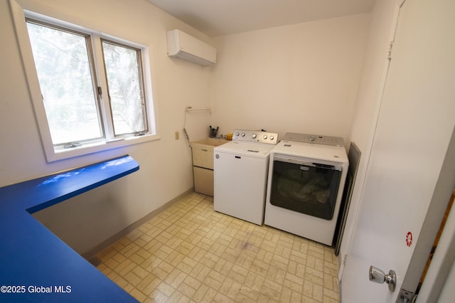 washroom featuring washing machine and clothes dryer, brick patterned floors, baseboards, and an AC wall unit