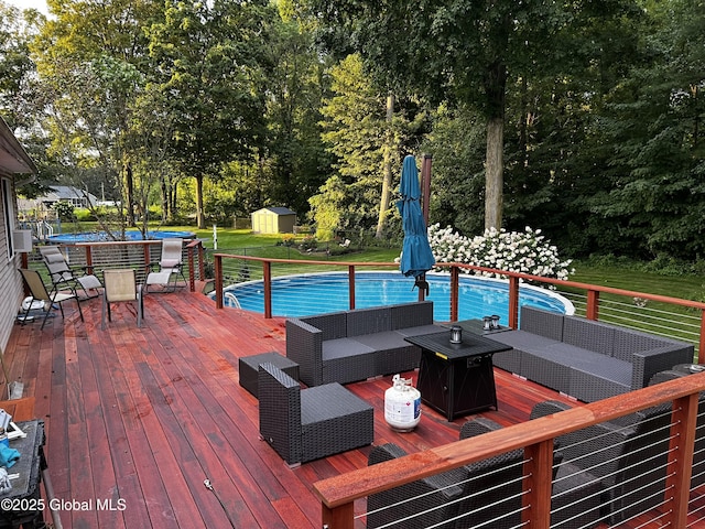 25 Hilton Dr, Moreau, NY 12803 - outdoor pool with a wooden deck, a storage unit, an outdoor living space with a fire pit, an outbuilding, and outdoor dining area