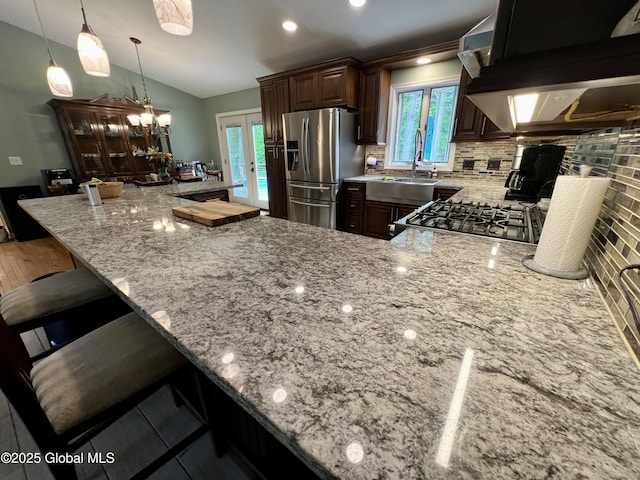 25 Hilton Dr, Moreau, NY 12803 - kitchen with stainless steel fridge, light stone counters, under cabinet range hood, tasteful backsplash, and vaulted ceiling