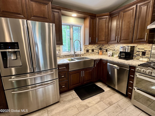 25 Hilton Dr, Moreau, NY 12803 - kitchen with stainless steel appliances, a sink, decorative backsplash, dark brown cabinetry, and light stone countertops