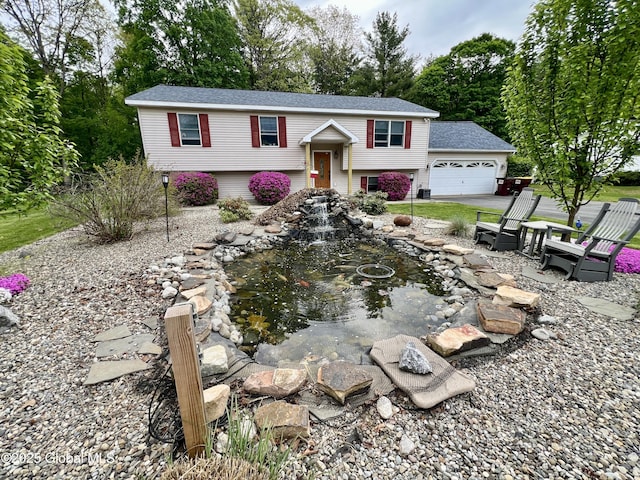 25 Hilton Dr, Moreau, NY 12803 - raised ranch with a garage, a small pond, and a shingled roof