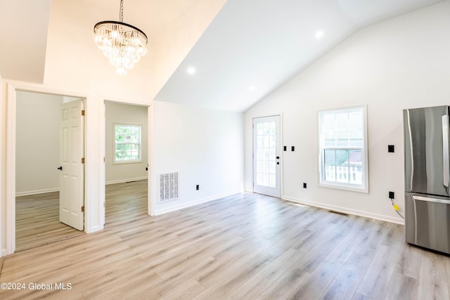 15 Schaffer Dr, Colonie, NY 12047 - unfurnished living room with light wood-type flooring, high vaulted ceiling, a chandelier, and baseboards