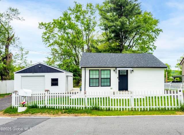 15 Schaffer Dr, Colonie, NY 12047 - view of front of property with an outbuilding, a detached garage, roof with shingles, and driveway