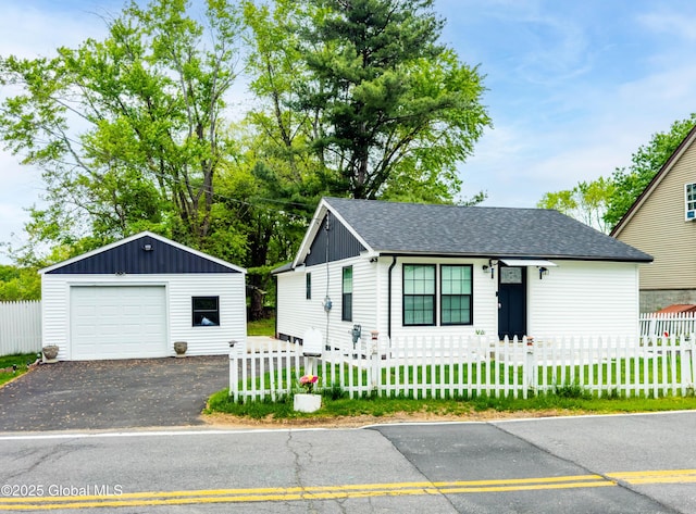 15 Schaffer Dr, Colonie, NY 12047 - view of front facade featuring a garage, an outdoor structure, asphalt driveway, and a fenced front yard