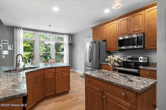 264 Edie Rd, Wilton, NY 12866 - kitchen featuring appliances with stainless steel finishes, a sink, a center island, light wood-style floors, and brown cabinetry