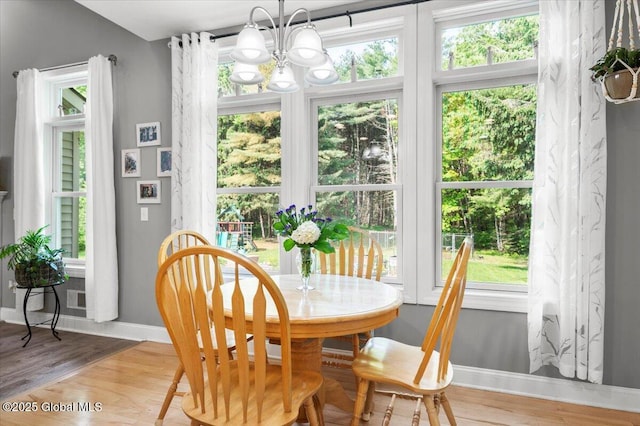 264 Edie Rd, Wilton, NY 12866 - dining space featuring a chandelier, baseboards, wood finished floors, and plenty of natural light