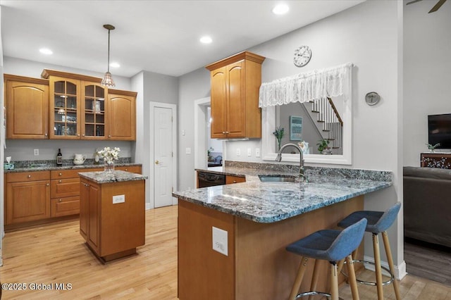 264 Edie Rd, Wilton, NY 12866 - kitchen featuring a peninsula, a sink, glass insert cabinets, light wood-type flooring, and dark stone countertops