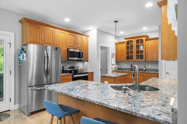 264 Edie Rd, Wilton, NY 12866 - kitchen featuring appliances with stainless steel finishes, a sink, brown cabinets, glass insert cabinets, and recessed lighting
