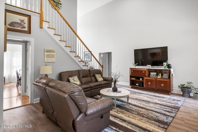264 Edie Rd, Wilton, NY 12866 - living room featuring a high ceiling, stairway, wood finished floors, and baseboards