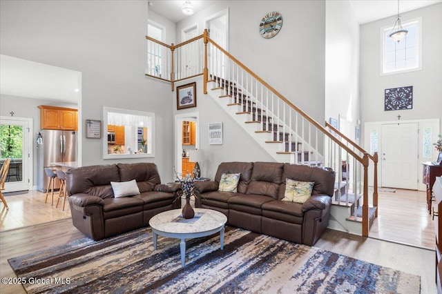 264 Edie Rd, Wilton, NY 12866 - living room featuring a high ceiling, light wood-type flooring, stairs, and baseboards