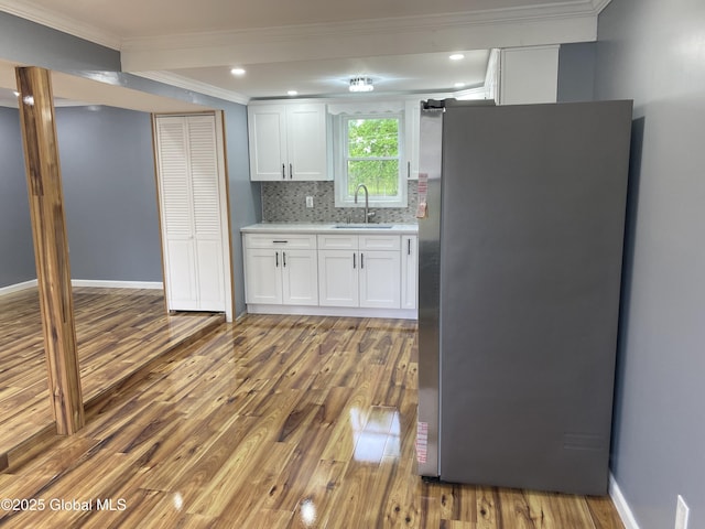2112 Gray St, Rotterdam, NY 12306 - kitchen featuring freestanding refrigerator, a sink, ornamental molding, wood finished floors, and light countertops