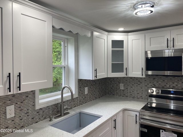 2112 Gray St, Rotterdam, NY 12306 - kitchen featuring stainless steel appliances, a sink, white cabinetry, backsplash, and glass insert cabinets