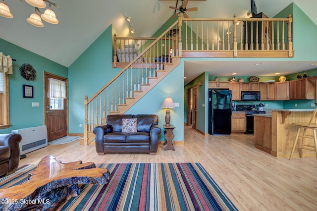 324 County Highway 112, Bleecker, NY 12078 - living room with high vaulted ceiling, light wood finished floors, stairway, ceiling fan, and heating unit