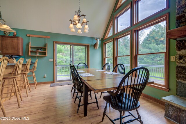 324 County Highway 112, Bleecker, NY 12078 - dining room with a chandelier, baseboards, light wood-style floors, healthy amount of natural light, and high vaulted ceiling