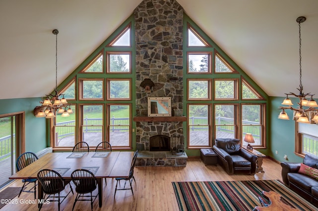 324 County Highway 112, Bleecker, NY 12078 - living area featuring a chandelier, high vaulted ceiling, wood finished floors, a stone fireplace, and baseboards