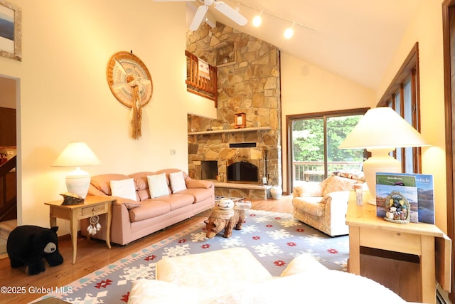 441 E Kelm Pond Rd, Warrensburg, NY 12885 - living area with wood finished floors, track lighting, high vaulted ceiling, a ceiling fan, and a fireplace