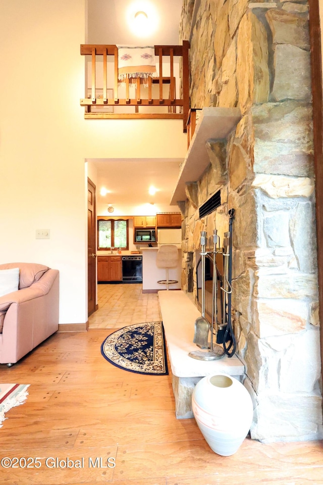 441 E Kelm Pond Rd, Warrensburg, NY 12885 - living room featuring light wood-style floors, a towering ceiling, and baseboards