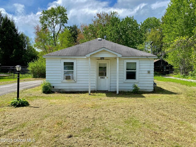 6963 Fuller Station Rd, Schenectady, NY 12303 - view of front facade with a front lawn, a shingled roof, cooling unit, and view of scattered trees