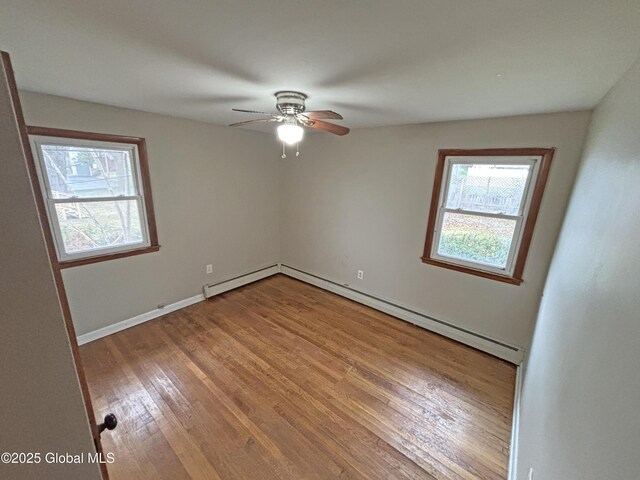 3 Schuyler Ave, Ravena, NY 12143 - empty room featuring baseboard heating, wood finished floors, a ceiling fan, and baseboards