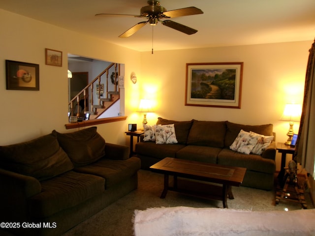 carpeted living room with stairs and a ceiling fan