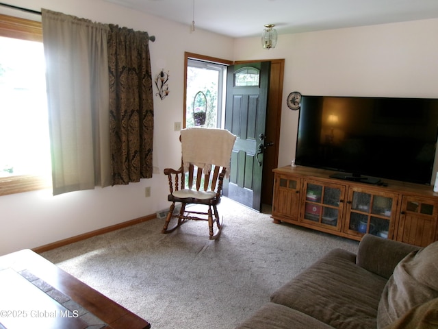 carpeted living area featuring baseboards