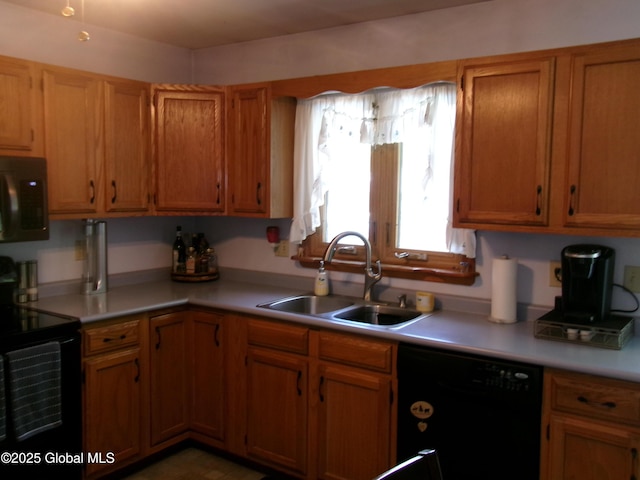 kitchen featuring black appliances, a sink, light countertops, and brown cabinets