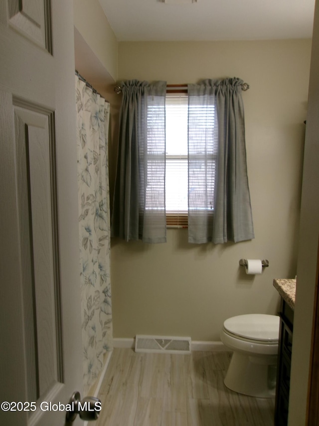 full bath with vanity, toilet, baseboards, curtained shower, and wood finished floors