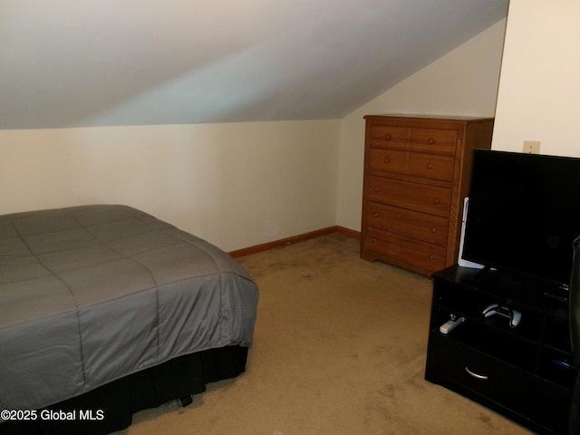 bedroom featuring lofted ceiling, light carpet, and baseboards