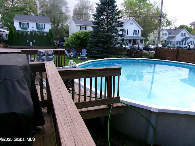 outdoor pool featuring fence and a residential view