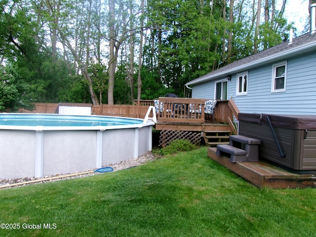swimming pool featuring a wooden deck and a hot tub