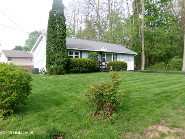 view of front of property featuring an attached garage, a front lawn, and asphalt driveway